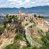 Civita di Bagnoregio, un borgo arroccato su una rupe, si trova in provincia di Viterbo. La sua bellezza è unica, raggiungibile solo tramite un lungo ponte pedonale.