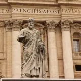 Statua di San Pietro davanti alla Basilica. La scritta "IN HONOREM PRINCIPIS APOST PAVLSV-BVRGHESIVS" celebra i santi Pietro e Paolo.
