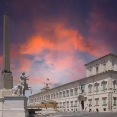Il Quirinale, Colle Romano, con obelisco e scultura equestre sotto un cielo infuocato.