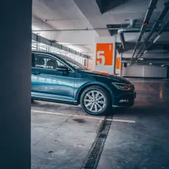 Auto blu parcheggiata nel parcheggio della metro Cipro, con numeri arancioni sulle colonne.