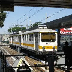 Treno della metro C a Torrenova, con segnale "Binario N°1 - N°2". Persone in attesa sul binario.