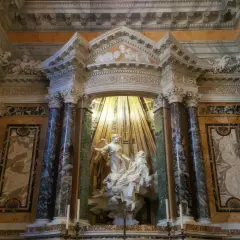 Estasi di Santa Teresa nella chiesa di Santa Maria della Vittoria, un capolavoro barocco con marmi policromi e luce dorata.