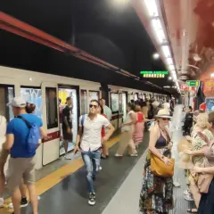 Persone in attesa del treno alla stazione Barberini di Roma.