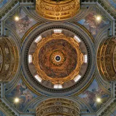 Soffitto affrescato di una delle magnifiche chiese barocche di Roma, con cupola centrale e decorazioni dorate.