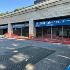 Roma, parcheggio gratuito metro EUR Palasport. Recinzione arancione davanti all'ingresso della metro.