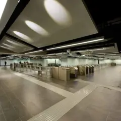 Ingresso moderno della metro Mirti con tornelli e illuminazione a soffitto.