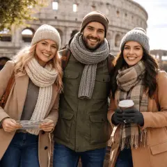 Tre amici sorridono davanti al Colosseo, vestiti a strati con cappelli e sciarpe. Perfetto per sapere come vestirsi a Roma in questi giorni!