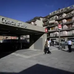 Ingresso della metro B1 Conca d'Oro a Roma, con persone che camminano e palazzi sullo sfondo.