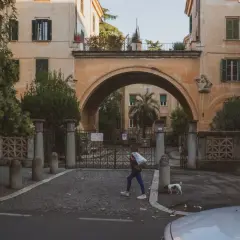 Una ragazza attraversa un arco a Montesacro, Roma. Scopri come arrivare in questo quartiere caratteristico.