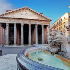 Fontana di Piazza della Rotonda Pantheon, con le sue sculture di delfini e volti, riflette la maestosità dell'edificio antico.