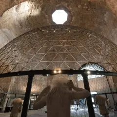 Interno di un'aula ottagona con cupola geodetica e sculture antiche. Luce zenitale illumina l'ambiente.
