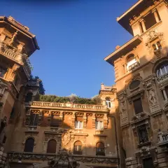 Edifici in stile liberty a Roma, con dettagli architettonici ricchi e un cielo azzurro intenso.