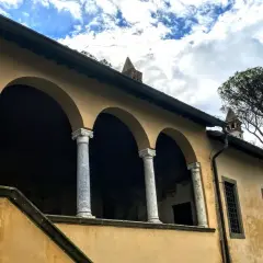 Portico con archi e colonne di marmo della casina cardinal Bessarione, con un grande albero sullo sfondo.