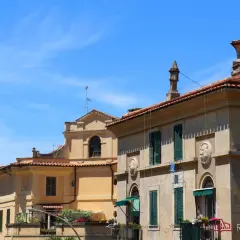 Edifici storici con tetti rossi e finestre verdi a Garbatella, un quartiere romano da scoprire.