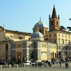 Piazza con chiese barocche, cupole e campanile. Un itinerario ideale per scoprire la Roma barocca, con gente che passeggia e auto.