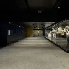 Corridoio moderno con reperti antichi esposti in teche di vetro, un omaggio ai Fori Imperiali, vicino alla metro C Roma Colosseo.