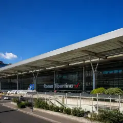 La moderna stazione di Roma Tiburtina, con la sua architettura in vetro e acciaio, accoglie viaggiatori diretti verso la metropolitana e oltre.