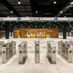 Cancelli automatici di una moderna stazione metro a Roma, con indicazioni per le fermate e i treni.