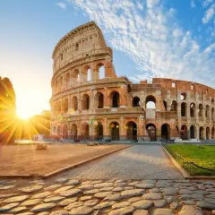 Il Colosseo all'alba, con i raggi del sole che illuminano l'anfiteatro. Vicino alla fermata metro Colosseo, linea B.