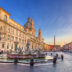 Fontana dei Quattro Fiumi e il palazzo prospiciente in Piazza Navona, Roma, al tramonto.