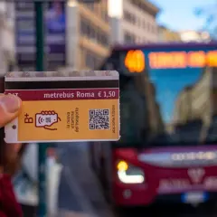 Un biglietto Metrebus Roma da 1,50€, la nuova vitamina del trasporto, pronto per essere usato su un bus rosso in città.