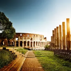 Il Colosseo e le colonne antiche, un'icona tra le 20 cose da vedere a Roma, illuminate dal sole del tramonto.