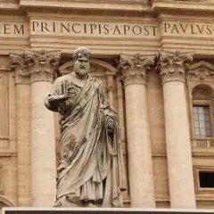 Statua di San Pietro davanti alla Basilica. La scritta "IN HONOREM PRINCIPIS APOST PAVLSV-BVRGHESIVS" celebra i santi Pietro e Paolo.