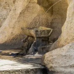 Antica fontana degli innamorati a Roma, scolpita nella roccia, con acqua che scorre.