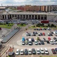 Ampio parcheggio di autobus e auto vicino alla stazione metro di Roma. Molti mezzi di trasporto pubblico e privato in un'area trafficata.
