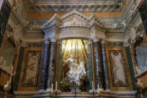 Estasi di Santa Teresa nella chiesa di Santa Maria della Vittoria, un capolavoro barocco con marmi policromi e luce dorata.