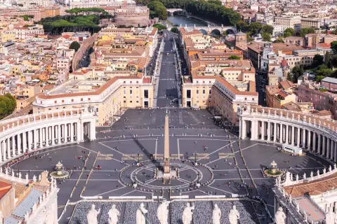 Vista aerea di Piazza San Pietro a Roma, con il colonnato, l'obelisco e la folla di fedeli.