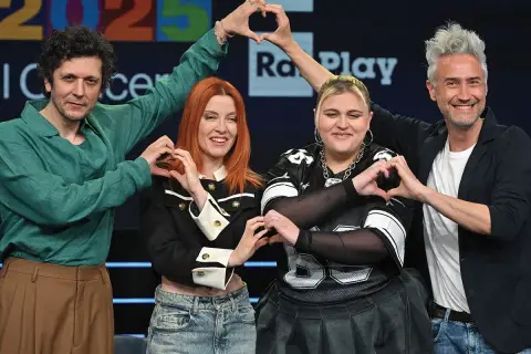 Artisti sorridono formando cuori con le mani, pronti per il concerto Roma 1 Maggio.
