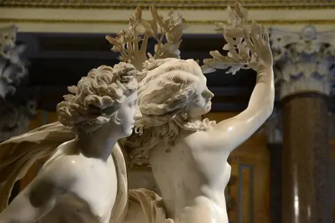 Marmo scolpito nella Galleria Borghese, Roma: due figure mitologiche con ghirlande di foglie.
