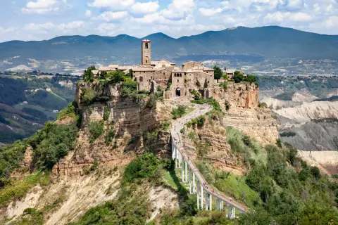 Civita di Bagnoregio, un borgo arroccato su una rupe, si trova in provincia di Viterbo. La sua bellezza è unica, raggiungibile solo tramite un lungo ponte pedonale.