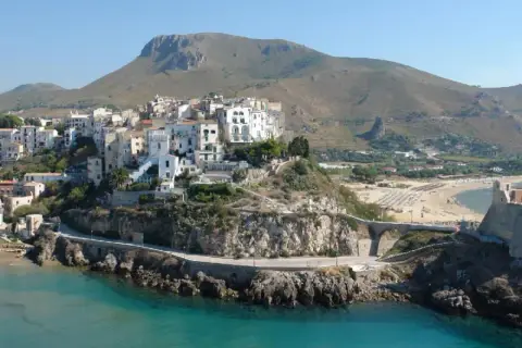 Panoramica di Sperlonga: cosa vedere tra il borgo bianco arroccato, la spiaggia dorata e l'antica torre sul promontorio roccioso.