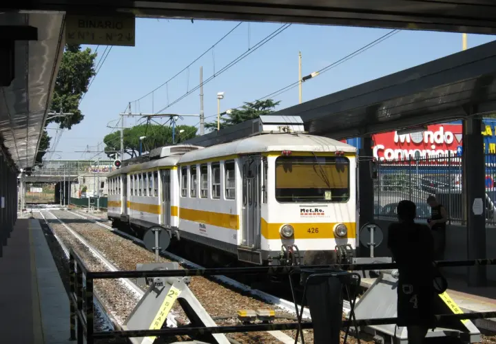 Treno della metro C a Torrenova, con segnale "Binario N°1 - N°2". Persone in attesa sul binario.