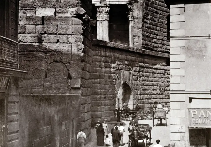 Antica strada romana, forse la Suburra, con carrozze e persone.
