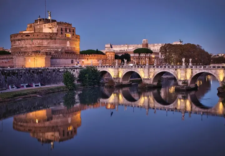 Castel Sant'Angelo illuminato di sera, riflesso sul Tevere. Un'idea romantica per cosa fare a San Valentino a Roma.