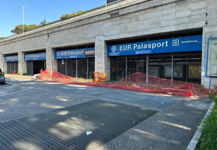 Roma, parcheggio gratuito metro EUR Palasport. Recinzione arancione davanti all'ingresso della metro.