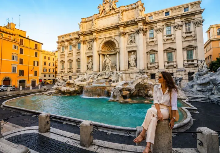 Donna seduta vicino alla Fontana di Trevi, un'icona di Roma. Perfetto per chi cerca dove dormire a Roma e vivere la magia della città eterna.