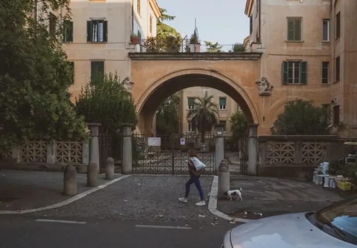 Una ragazza attraversa un arco a Montesacro, Roma. Scopri come arrivare in questo quartiere caratteristico.
