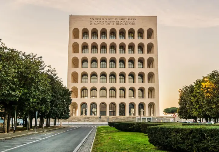 Il Palazzo della Civiltà Italiana, con le sue arcate iconiche, si erge maestoso. All'interno, le statue e le finestre creano un'atmosfera di grandezza.