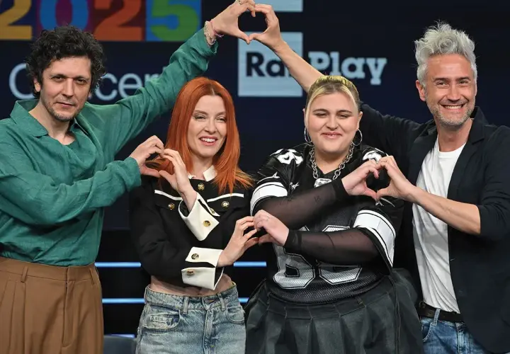 Artisti sorridono formando cuori con le mani, pronti per il concerto Roma 1 Maggio.