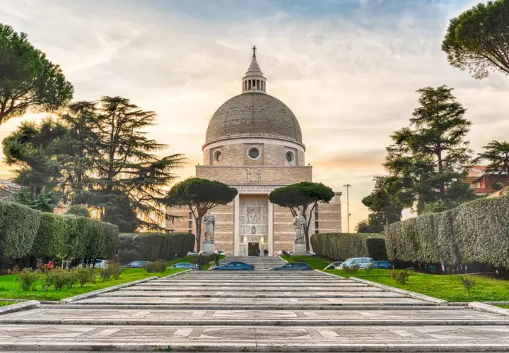 La Basilica dei Santi Pietro e Paolo a Roma, con la sua imponente cupola, si erge maestosa tra alberi secolari e giardini curati.