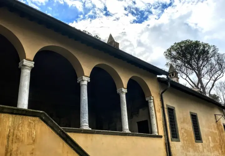 Portico con archi e colonne di marmo della casina cardinal Bessarione, con un grande albero sullo sfondo.