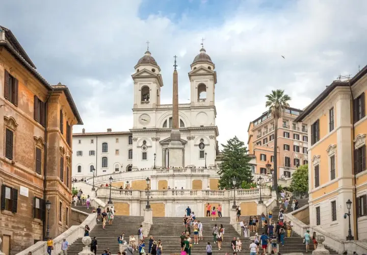 Scalinata di Trinità dei Monti, un must per chi cerca cosa vedere a Roma in una settimana. Turisti salgono i gradini verso la chiesa con obelisco.