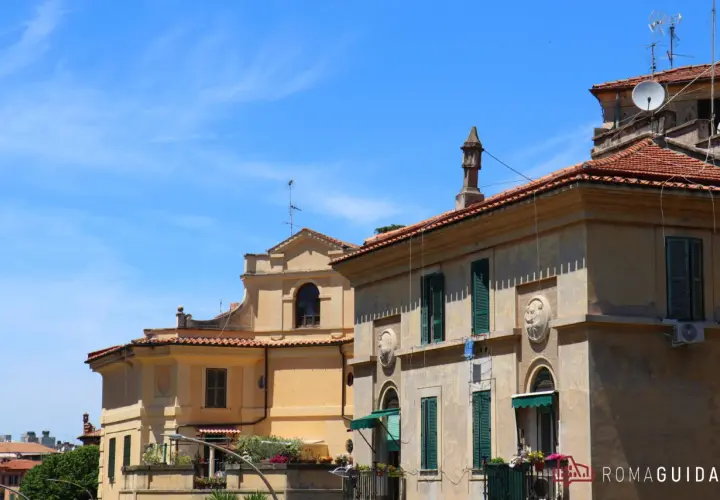 Edifici storici con tetti rossi e finestre verdi a Garbatella, un quartiere romano da scoprire.