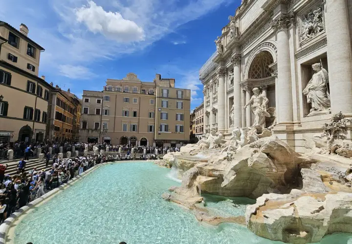 Fontana di Trevi, una delle più celebri fontane di Roma, con una folla di turisti che ammirano la sua maestosità.
