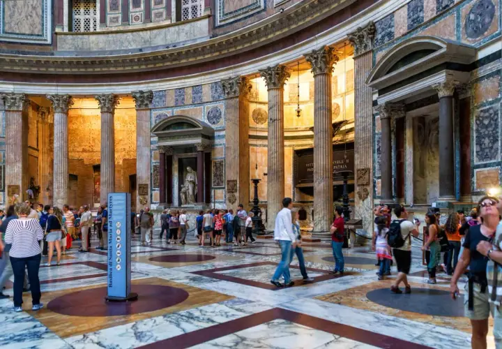 Interno del Pantheon a Roma, con turisti che ammirano la maestosa architettura e le colonne. La Piazza della Rotonda è un luogo iconico.