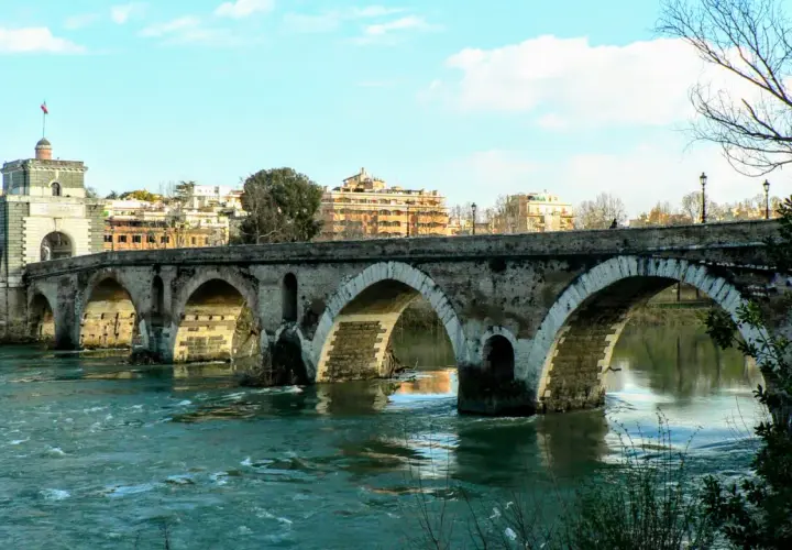 Ponte Sisto attraversa il fiume Tevere, collegando il centro storico con Trastevere. Le sue arcate di pietra riflettono sull'acqua.